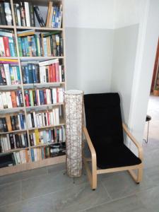 a chair in front of a book shelf with books at Hotel Neos Matala in Matala
