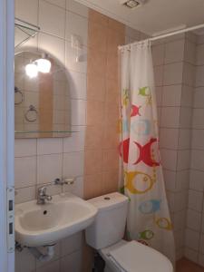 a bathroom with a sink and a toilet and a shower curtain at Hotel Neos Matala in Matala