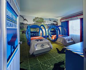 a room with two beds and a mural of a zoo at Universal's Loews Royal Pacific Resort in Orlando