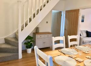 a dining room with a table and a staircase at Eden Cottage in Frodsham