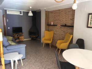 sala de estar con sofá, sillas y mesa en La casa del perelló, en Sueca