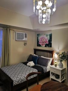 a bedroom with a bed and a chandelier at Davao Boutique Condos - Avida in Davao City