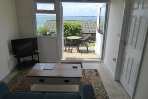a living room with a view of the ocean at Pebble Lodges in Gurnard