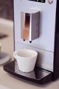 a coffee cup on a black tray next to a microwave at Living In Aparthotel in Oradea