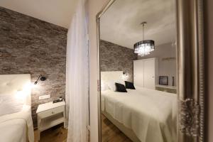 a bedroom with a white bed and a mirror at Aldo Apartments Center in Zadar