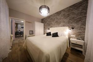 a bedroom with a large white bed and a brick wall at Aldo Apartments Center in Zadar