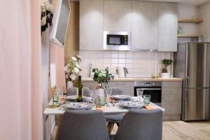 a kitchen with a table and chairs and a kitchen with a refrigerator at Aldo Apartments Center in Zadar