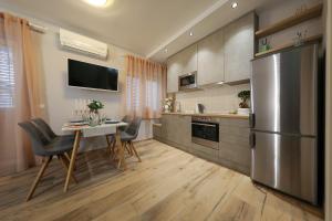 a kitchen with a table and a stainless steel refrigerator at Aldo Apartments Center in Zadar