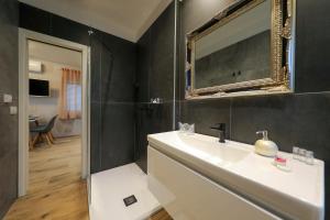 a bathroom with a sink and a mirror at Aldo Apartments Center in Zadar