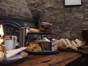 a table with cakes and pastries and a cup of coffee at The Penrhos Arms in Cemmaes