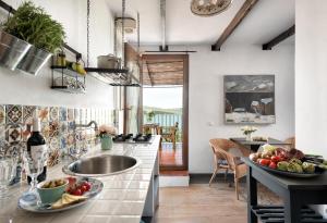 a kitchen with a sink and a bowl of fruit on the counter at El Arpa in El Chorro