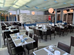a dining room filled with tables and chairs at Villaggio Hemingway - Aparthotel in Caorle