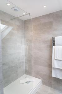 een badkamer met een douche en een glazen deur bij Citystay - Park House in Cambridge