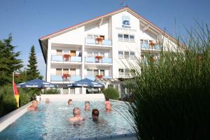 a group of people in a swimming pool in a hotel at Apartmenthaus Gass in Bad Füssing