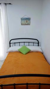 a bed with a green pillow on top of it at Dream Acropolis Flat in Athens