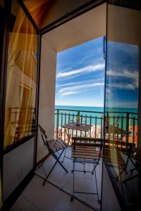a balcony with a table and chairs and the ocean at Casanova Rooms and Apartment to Rent in Cefalù