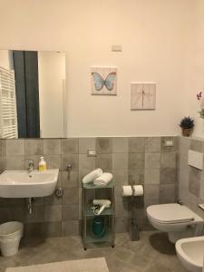 a bathroom with a sink and a toilet and a mirror at Appartamenti I Giardini Di Villa Melzi in Bellagio