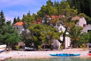 a blue kayak on the water in front of a house at Vrnik Arts Club in Korčula
