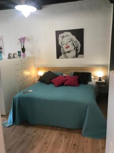 a bedroom with a green bed with red pillows at Appartamenti I Giardini Di Villa Melzi in Bellagio