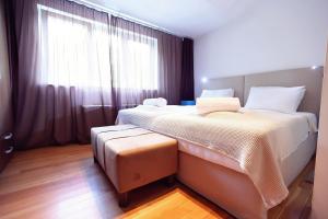 um quarto com uma cama grande e uma janela grande em Living In Aparthotel em Oradea