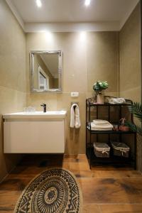 a bathroom with a sink and a mirror and a rug at Aldo Apartments Center in Zadar