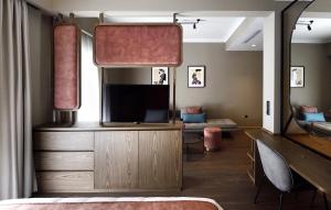 sypialnia z telewizorem i dużym lustrem w obiekcie Roomore Apartments w Salonikach
