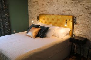 a bedroom with a bed with a yellow headboard and pillows at Aldo Apartments Center in Zadar