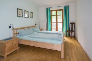 een slaapkamer met een bed, een stoel en een raam bij Balsnhof in Chamerau