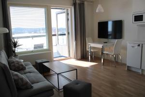 a living room with a couch and a table at Sonaatti Studio - best lake view in Jyväskylä