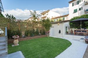 een kleine achtertuin met een hek en gras bij Le stanze di Carla! Con cucina e bagno privato in Florence
