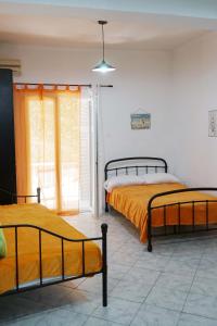 two beds in a room with a window at Dream Acropolis Flat in Athens