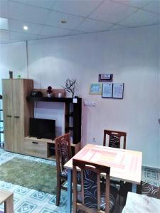ein Esszimmer mit einem Tisch und Stühlen sowie einem TV in der Unterkunft Apartments Barocco in Golubac