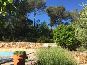 un jardín con una pared de piedra y una piscina en Vila Familia Hvar, en Vrboska