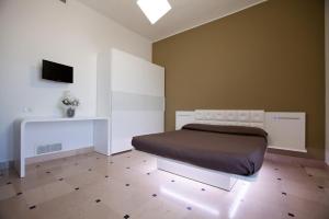 トッレ・サン・ジョヴァンニ・ウジェントにあるHyencos Hotel Calosのベッドルーム1室(ベッド1台、壁にテレビ付)