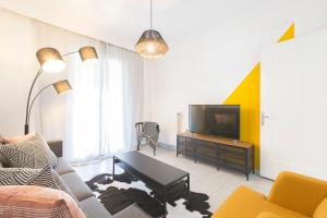 a living room with a couch and a tv at #FLH - Belle Reve Apartment in Thessaloniki
