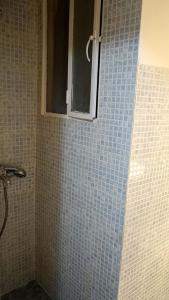 a bathroom with a blue tiled wall with a window at Dream Acropolis Flat in Athens