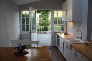 a kitchen with white cabinets and a large window at Maison Cornic in Crozon