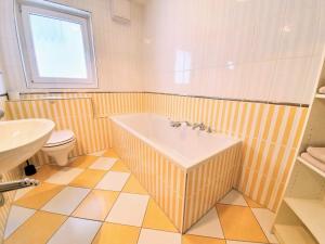 a bathroom with a tub and a toilet at Ferienwohnung Achtern Diek, inklusive Strandkorb und Stellplatz in Warnemünde +13 photos