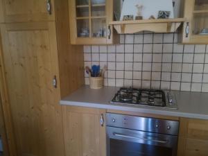 una cucina con armadi in legno e piano cottura. di Casa Lausen a Canal San Bovo