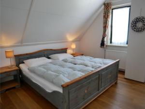 a bedroom with a large bed with white pillows at Buitenplaats Villa 5-p in Callantsoog