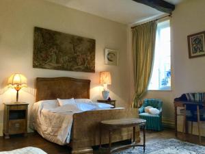 a bedroom with a bed and a table and a chair at AU TEMPS JADIS in Fumay