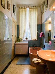 uma casa de banho com uma banheira, um WC e uma janela. em AU TEMPS JADIS em Fumay