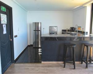 a kitchen with a black counter and a refrigerator at Bouad Seafront Apartments & Rooms in Taghazout