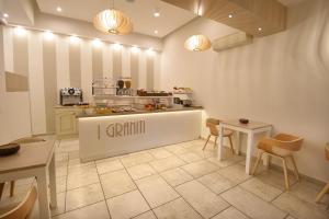 a restaurant with a counter and tables and chairs at Hotel I Graniti in Villasimius