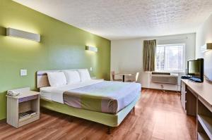 Habitación de hotel con cama grande y TV en Economy Inn en Moon