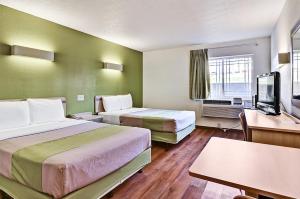 een hotelkamer met 2 bedden en een flatscreen-tv bij Economy Inn in Moon