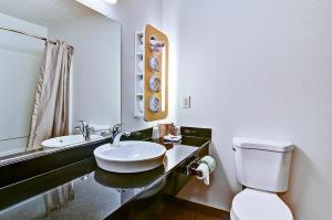 a bathroom with a sink and a toilet and a mirror at Economy Inn in Moon