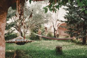 a hammock in a garden with grass and trees at Aventora Apartments in Lygia