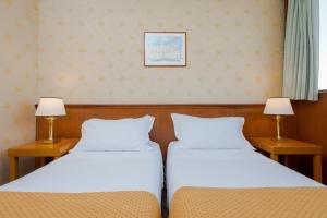 two beds sitting next to each other in a room at Hotel The Brand in Rome