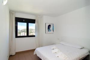 Una habitación blanca con una cama y una ventana en Apartamentos con terraza Torre D'Oboe by Renthas, en Benidorm 61 fotos más